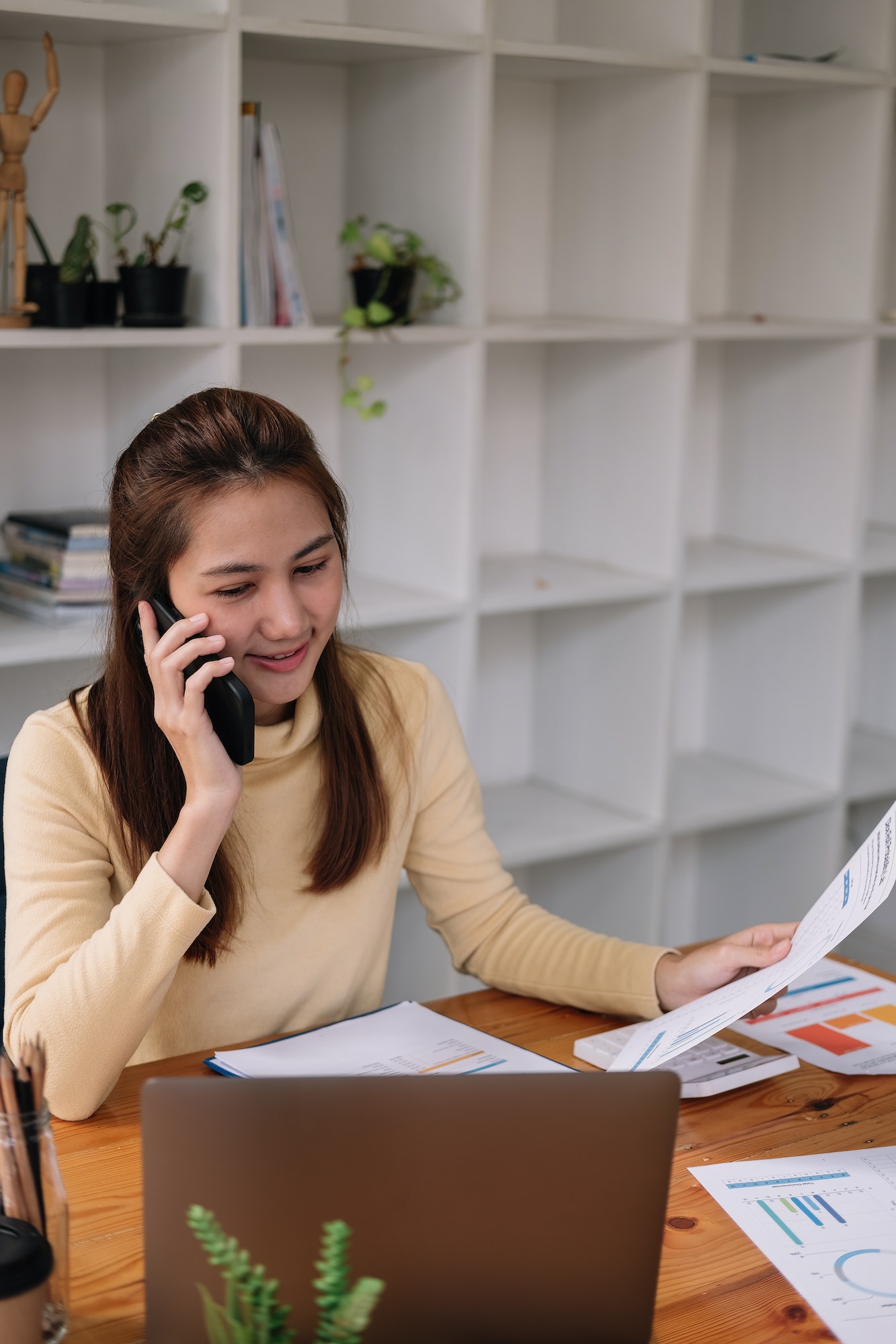 asian business woman making a phone call accountant working financial investment on calculator with